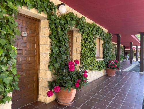 a building with potted plants and flowers on it at Hotel Rural "La Ruta De Cabrales" in Mestas de Con
