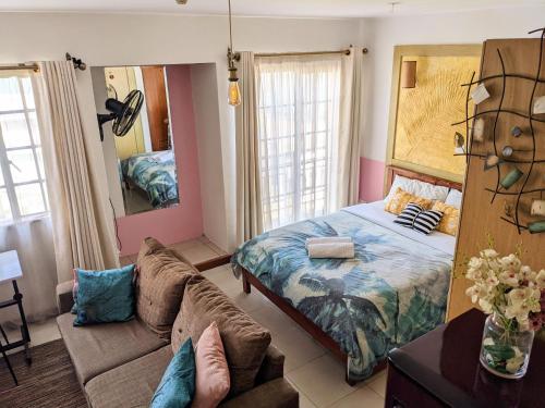ナイロビにあるHome and Away Cozy Studio Apartment number 407のベッドルーム(ベッド1台、ソファ付)