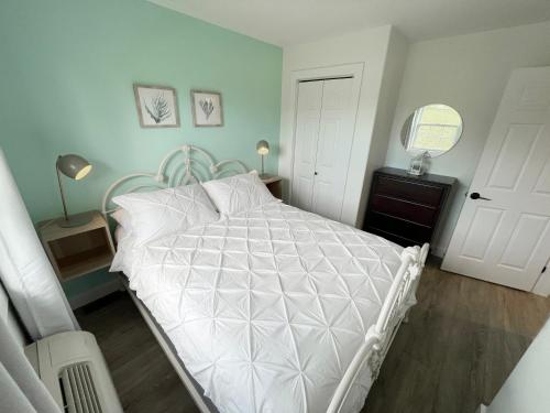 a bedroom with a bed with a white comforter at Gateway to Greenwich Suites in Saint Peters