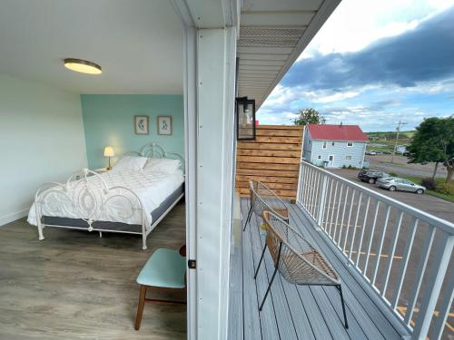 a bedroom on a balcony with a bed on a porch at Gateway to Greenwich Suites in Saint Peters