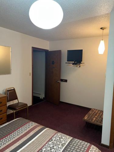 a hotel room with a bed and a flat screen tv at Barnesville Motel in Barnesville