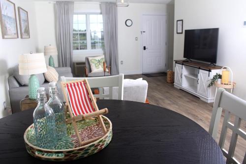 a living room with a table with a chair and a couch at Gateway to Greenwich Suites in Saint Peters