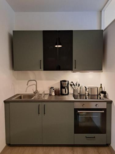a kitchen with a sink and a stove at Waldstadt-Apartments in Iserlohn
