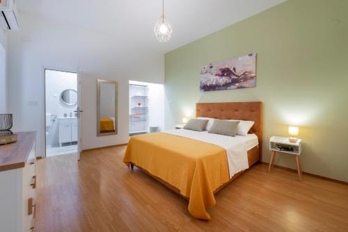 um quarto com uma cama grande e um cobertor laranja em Apartment Two Oranges em Dubrovnik