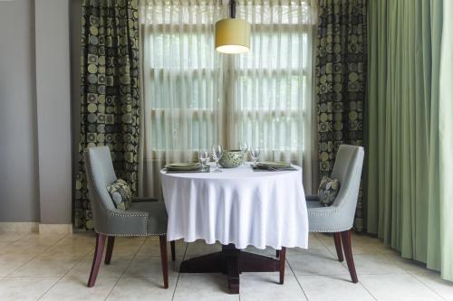 a dining room table with a white table cloth and chairs at Altos de Fontana by Macondo Collection in Managua