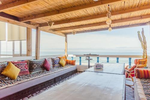 un soggiorno con divano e vista sull'oceano di L'Auberge Taghazout a Taghazout