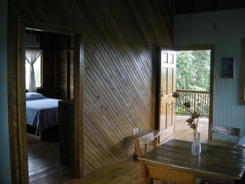 a room with a table and a bedroom with a bed at Apartments Chez Milady in Utila