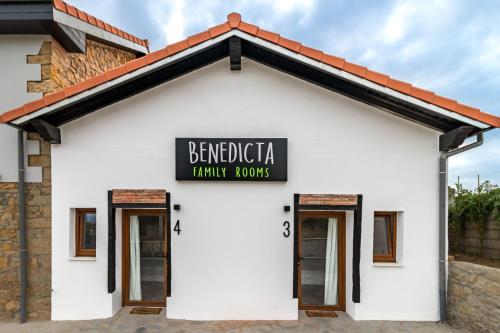 un edificio bianco con un cartello che recita "camere per famiglie Benedica" di BENEDICTA FAMILY ROOMS a Suances