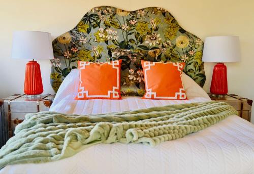a bedroom with a bed with a floral headboard at The Stables Hideaway in Llanelli