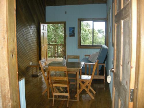 a dining room with a table and chairs and a window at Apartments Chez Milady in Utila