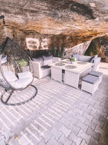 a patio with a swing and a table and chairs at Unicorn Hřensko in Hřensko