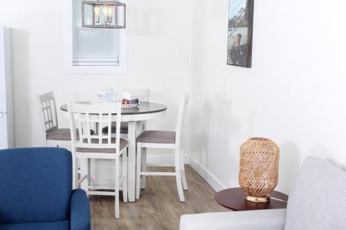 uma sala de estar com uma mesa branca e cadeiras em Gateway to Greenwich Suites em Saint Peters