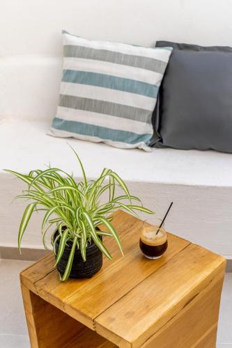a wooden table with a plant on top of a bed at Amer Suites in Fira