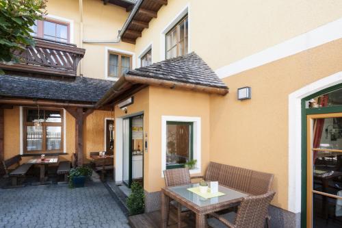 a patio with a table and chairs next to a building at Hotel-Gasthof Beim Böckhiasl in Neukirchen an der Vöckla