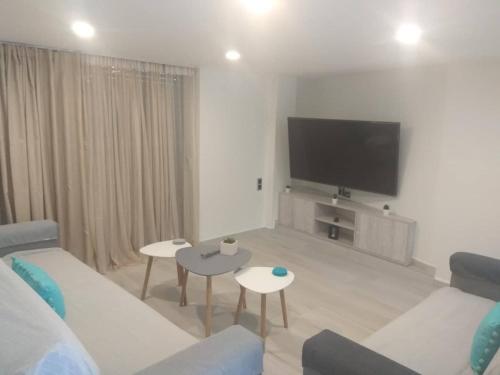 a living room with a couch and a flat screen tv at Malamatenia 's Maisonette in Mokhós