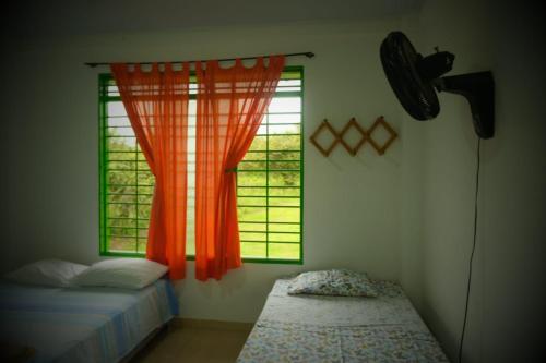 1 dormitorio con 2 camas y ventana naranja en Rivera Maya en Rivera
