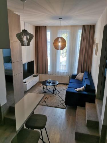 a living room with a blue couch and a tv at Studio apartment INDIGO in Osijek
