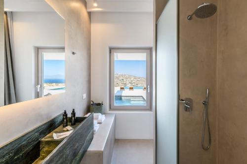 a bathroom with a sink and a mirror at Muro Suites in Ornos
