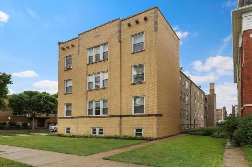 a large brick building with windows on a street at 2BR Alluring Apartment with Laundry - Cullom D3 in Chicago