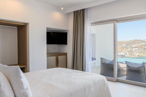 a hotel room with a bed and a large window at Muro Suites in Ornos