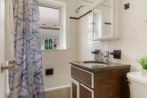 La salle de bains est pourvue d'un lavabo et d'une douche. dans l'établissement Alluring 2BR Apt in Old Irving Park with Laundry - Cullom D3, à Chicago
