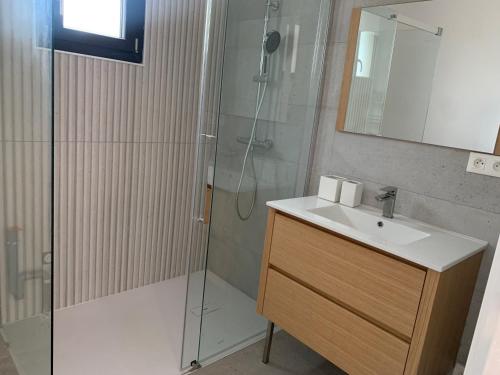 uma casa de banho com um chuveiro, um lavatório e um espelho. em Maison avec vue sur le massif de l Étoile em Marselha