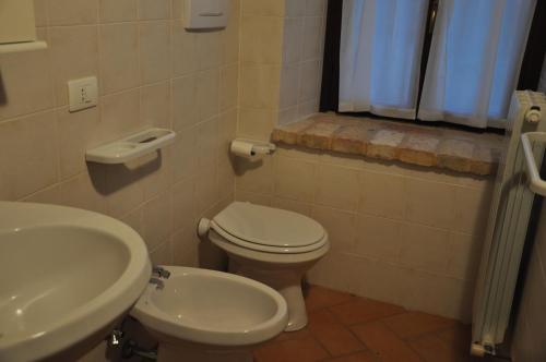 a bathroom with a toilet and a sink at Farmstay Agriturismo La Fonte in Belforte del Chienti