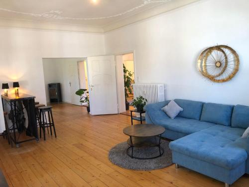 a living room with a blue couch and a table at Traumhaft wohnen in Jugendstilvilla in Speyer
