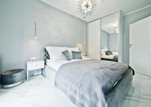 a bedroom with a large bed and a mirror at Unique Baltic Apartments - Apartament z garażem in Kołobrzeg