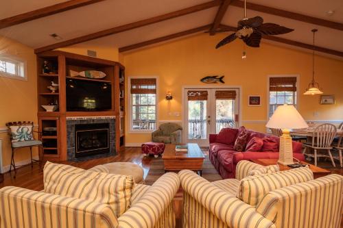 a living room with two couches and a fireplace at Woodlands Wonder by Oak Island Accommodations in Oak Island