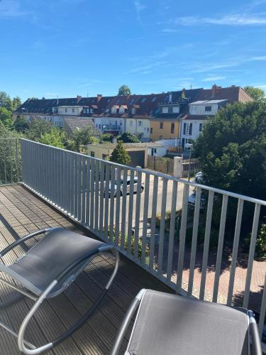 a chair on a deck with a view of a city at Traumhaft wohnen in Jugendstilvilla in Speyer