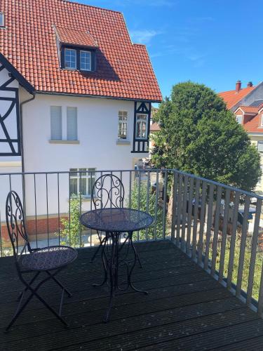a table and chairs on a balcony with a house at Traumhaft wohnen in Jugendstilvilla in Speyer