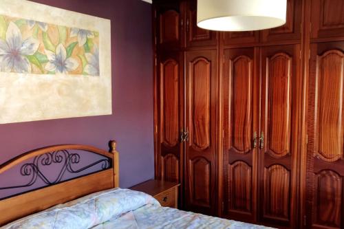 1 dormitorio con 1 cama y armarios de madera en Acogedor apartamento en Pontedeume, en Puentedeume