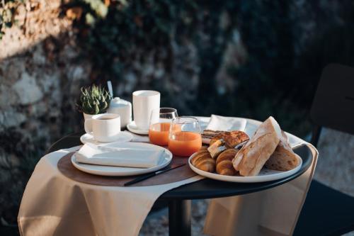 uma mesa coberta com um prato de pão e sumo de laranja em L'Iris de Suse em Le Barroux