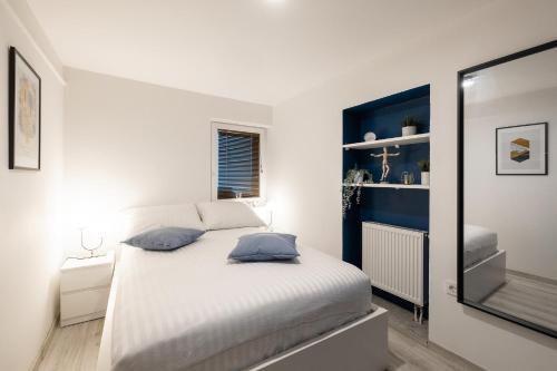 a bedroom with a bed with a blue accent wall at New Central Studio with Parking in Ljubljana