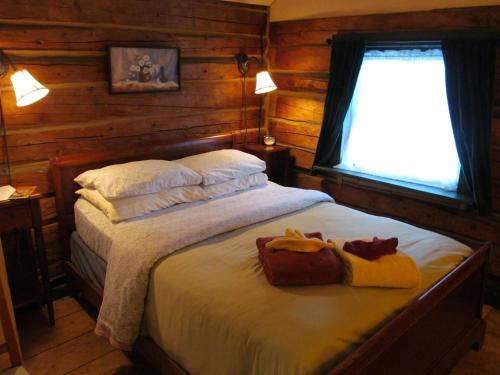 a bedroom with a bed with two towels on it at Talkeetna Roadhouse in Talkeetna