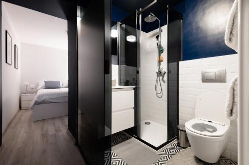 a bathroom with a toilet and a bed in it at New Central Studios with parking in Ljubljana