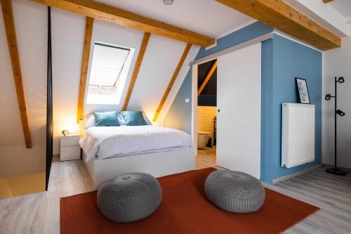 a bedroom with a bed and two ottomans at New Central Studios with parking in Ljubljana