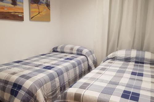 duas camas sentadas uma ao lado da outra num quarto em Centro Zaragoza, con parking incluido em Zaragoza