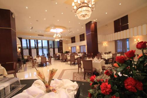 a dining room with tables and chairs and red roses at Capital Hotel and Spa in Addis Ababa
