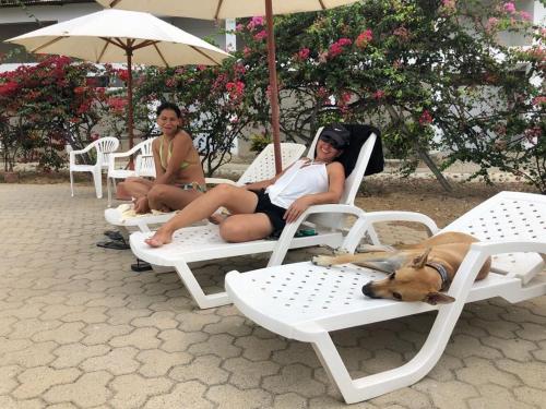 two women and a dog laying on lawn chairs at Amotape Comfort in Zorritos