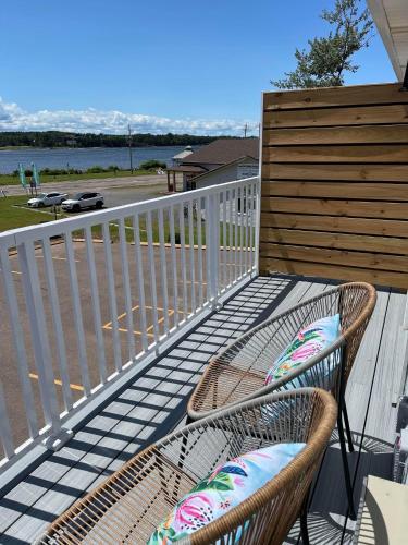 a balcony with a chair and a fence at Gateway to Greenwich Suites in Saint Peters
