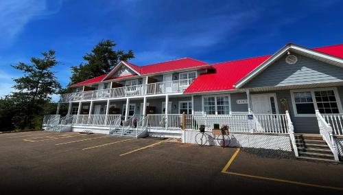 a large white building with a red roof at Gateway to Greenwich Suites in Saint Peters