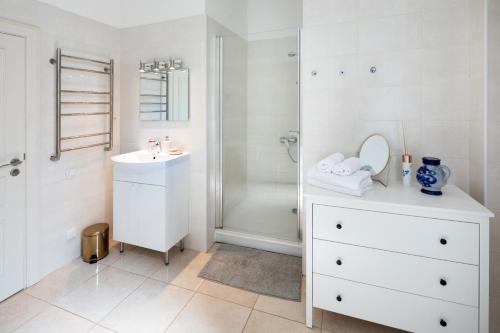 a white bathroom with a sink and a shower at Old Riga Modern and Spacious 2 bedroom Apartment in Rīga