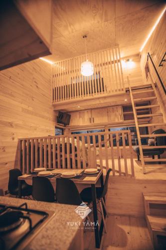 a dining room with a table and chairs and a staircase at Yuki Yama in Malalcahuello