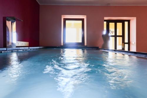 a swimming pool with blue water in a red room at Cascina il Faggio Country House in Mosso Santa Maria