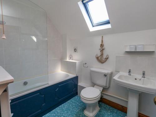 ein Badezimmer mit Toilette, Badewanne und Waschbecken in der Unterkunft The Little Cottage in Weymouth