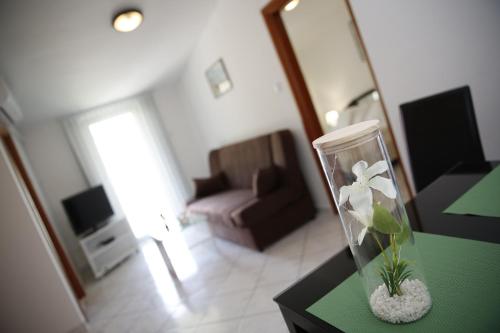 un soggiorno con un vaso con un fiore sul tavolo di Apartments Lepur a Vodice