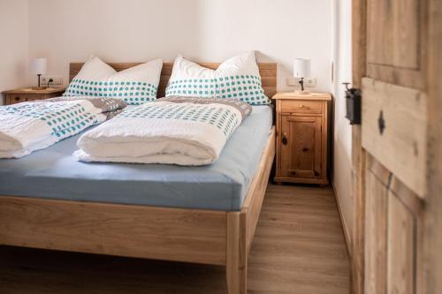 a bedroom with two beds with blue and white pillows at Steinergut Apartments in Sankt Martin bei Lofer