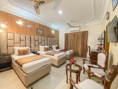 ein Hotelzimmer mit 2 Betten und einem TV in der Unterkunft World Inn Karachi in Karatschi